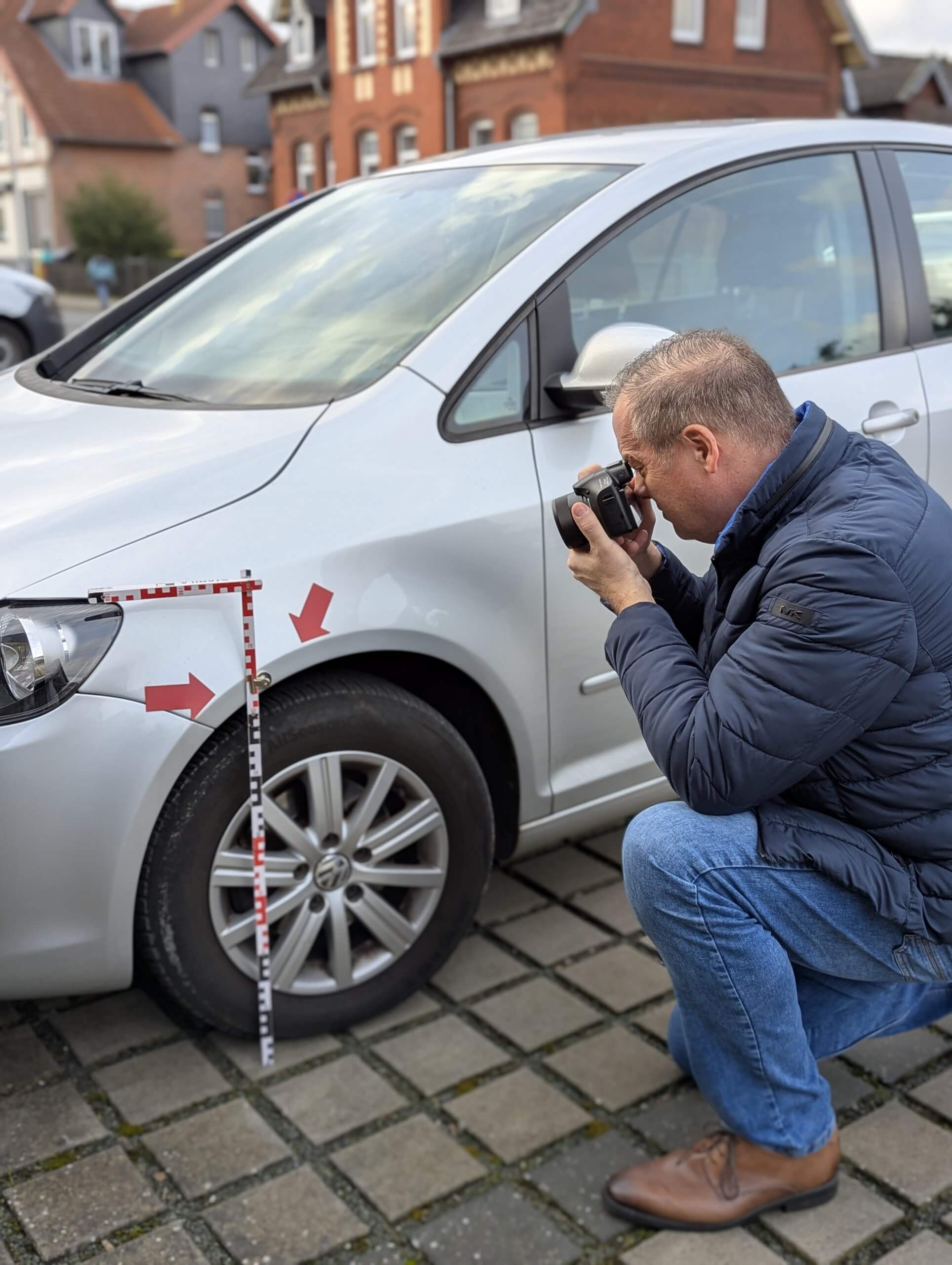 Der Kfz Gutachter Uwe Weinreich aus Garbsen fotografiert einen Unfallschaden an einem silbernen VW Golf Plus